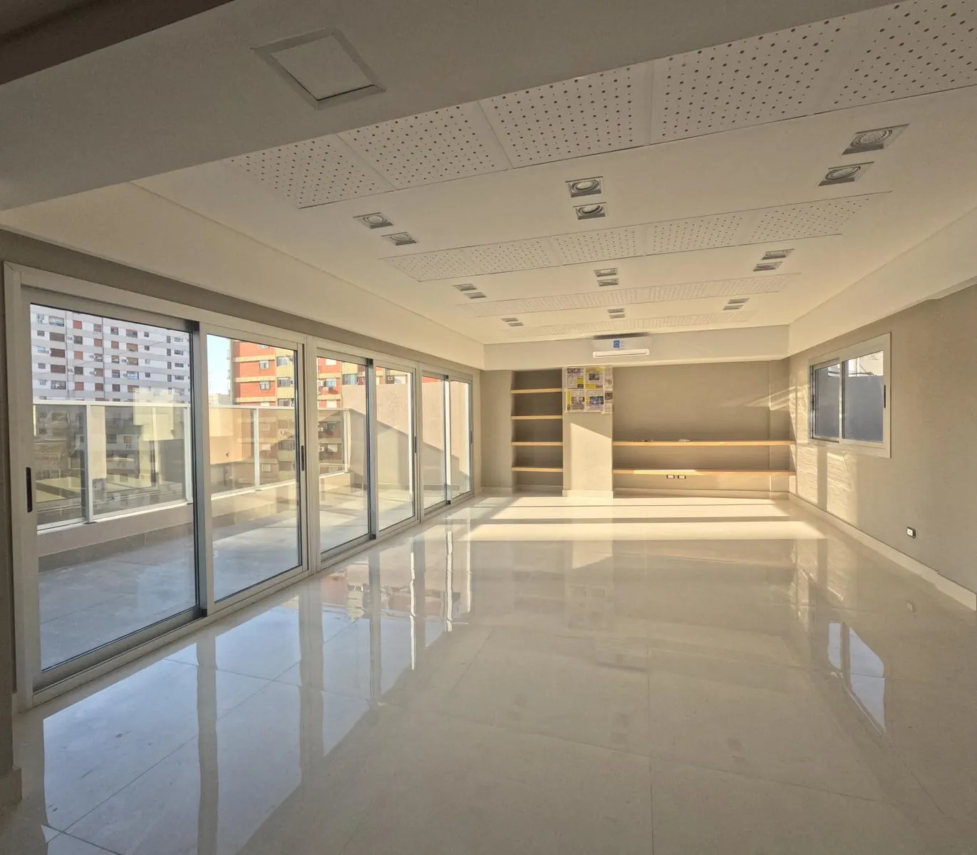 Unidad terminada con piso de porcelanato claro, cielorraso con luces embutidas y ventanales al frente